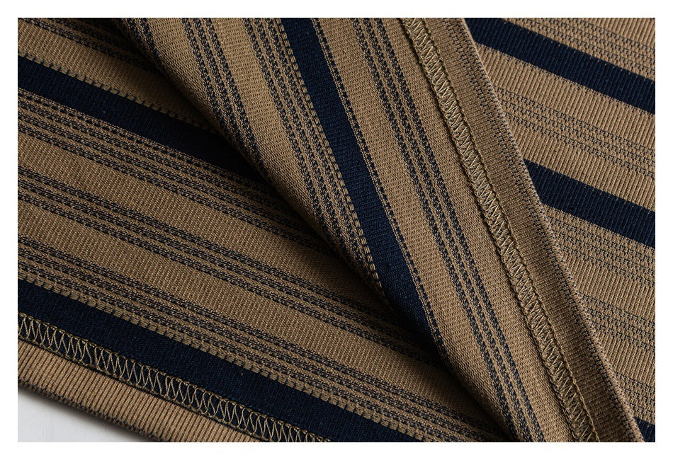 Close-up of tan knit fabric with navy stripes and stitched garment seams.