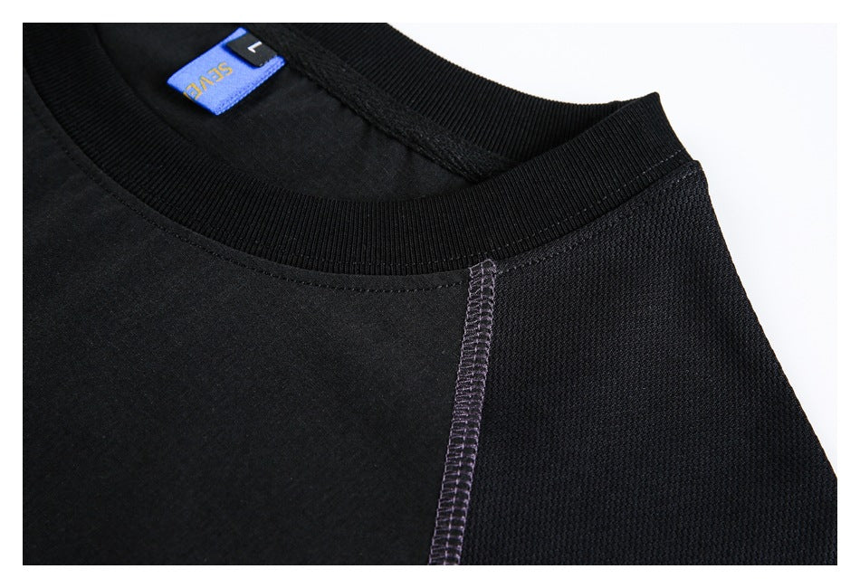 Close-up of a black crew neck and shoulder seam with purple stitching and a blue neck label.