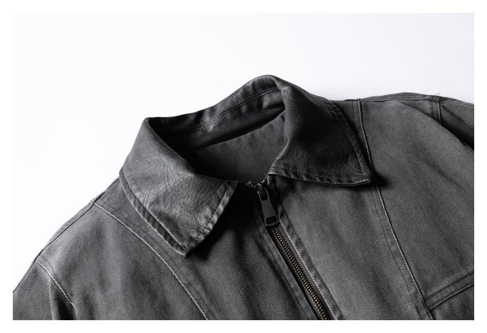 Close-up of a dark gray jacket's pointed collar, shoulder seams, and front zipper.
