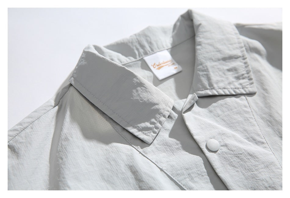 Close-up of the light gray pullover's collar, button placket, and inner neck label.