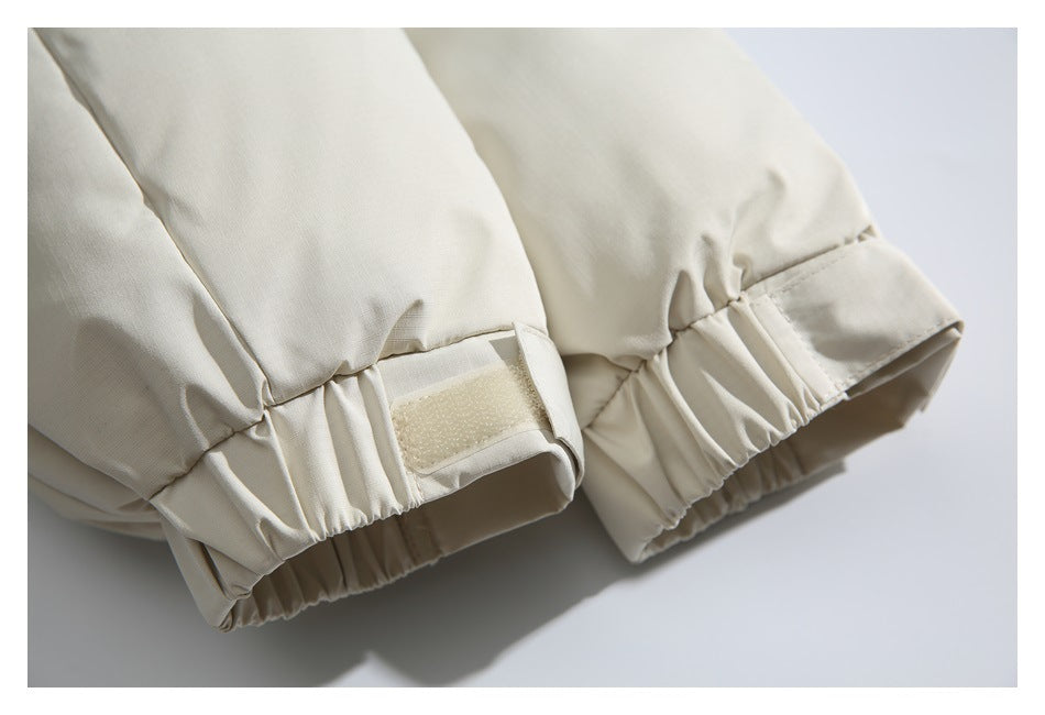 Close-up of the ivory jacket's elastic cuffs with adjustable hook-and-loop tabs.