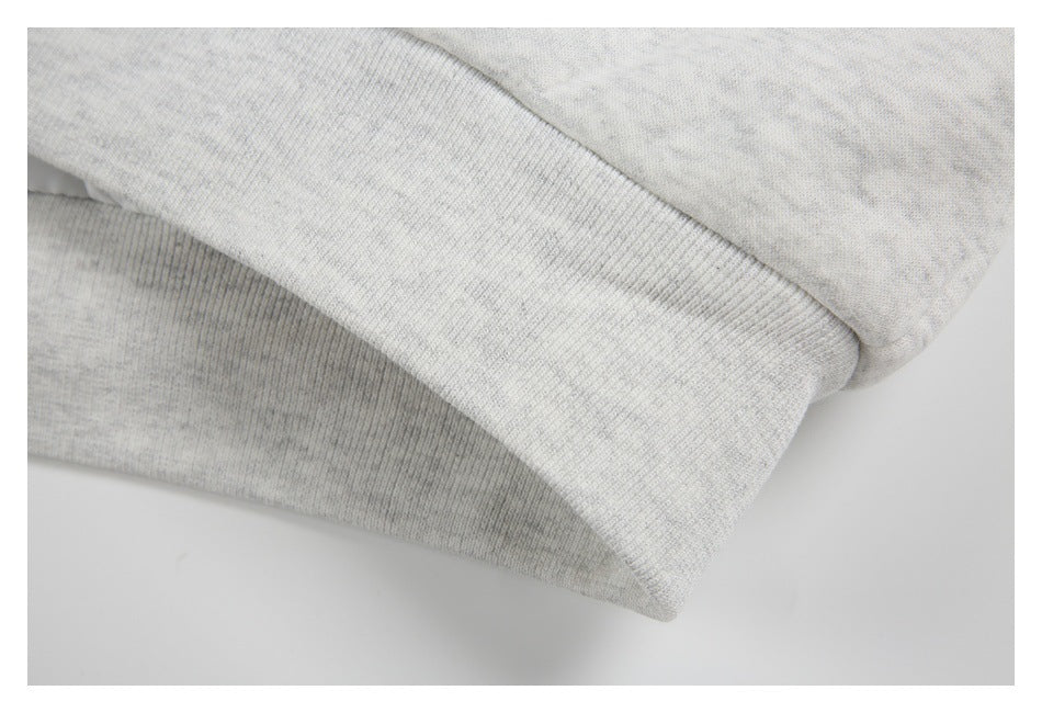 Close-up of a ribbed cuff on light gray marled fabric.