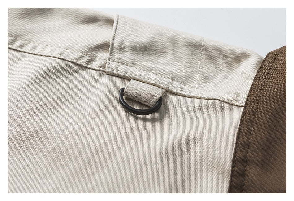 Close-up of a black D-ring attached at the shoulder seam of the ivory jacket.