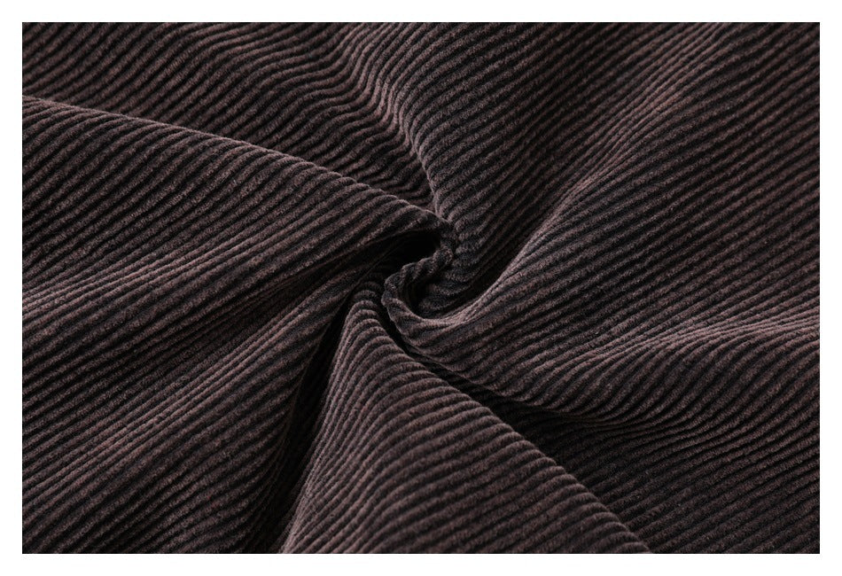 Close-up of dark brown ribbed fabric gathered into a swirl, showing its texture.