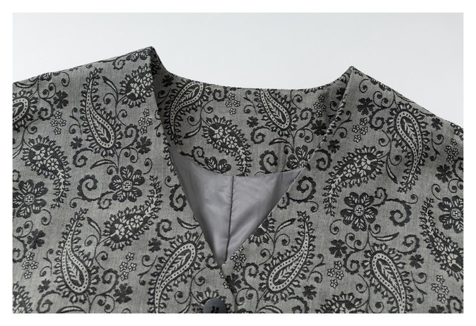 Close-up of the jacket's round neckline, patterned fabric, front opening, and gray lining.