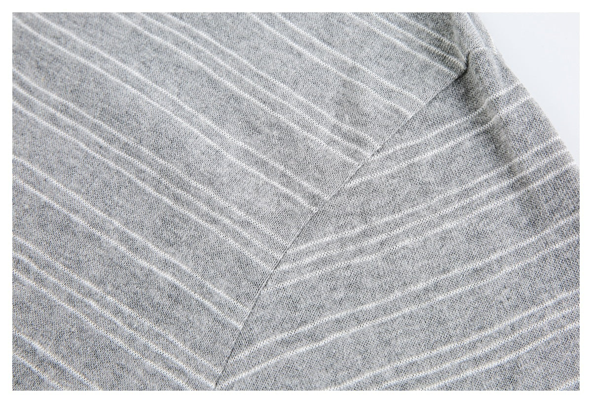 Close-up of a gray knit garment with thin white stripes and a diagonal seam.