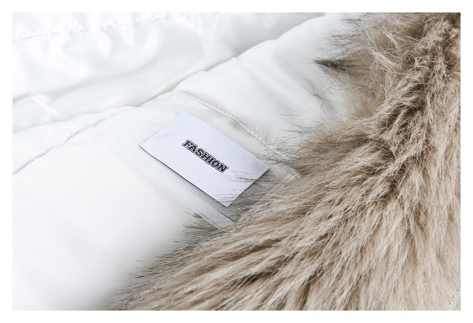 Close-up of a white garment with a beige faux-fur trim and a sewn label reading “FASHION.”