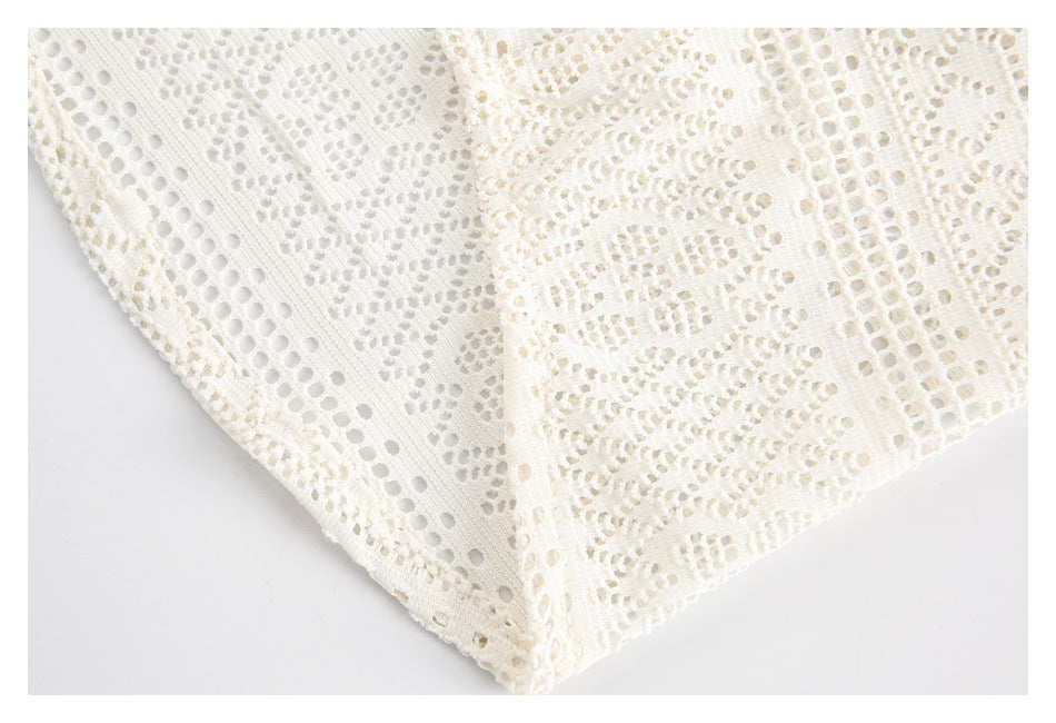 Close-up of the hem and openwork pattern on an ivory lace shirt.