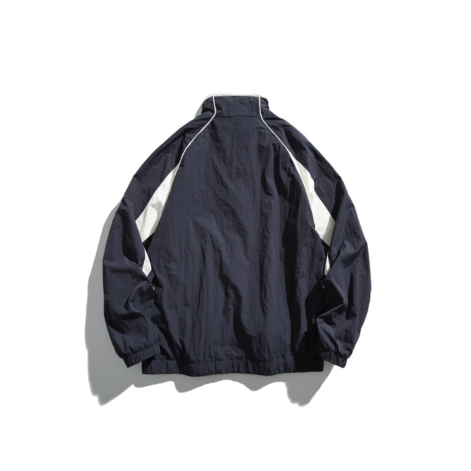 Back view of a dark navy windbreaker with white panels and piping, laid flat on a white background.
