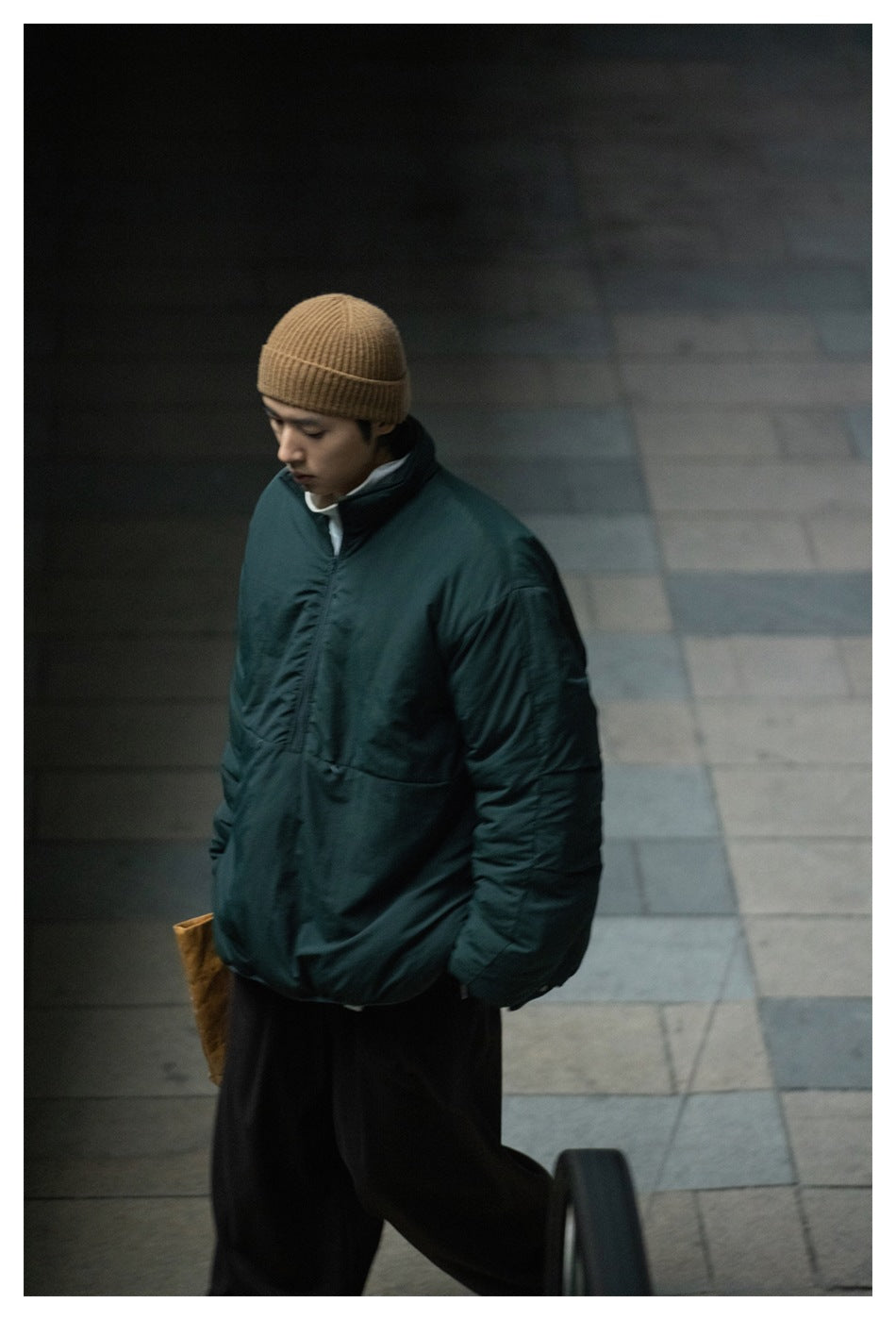 Model wearing an oversized dark teal jacket with a high collar, front zipper, and voluminous sleeves.