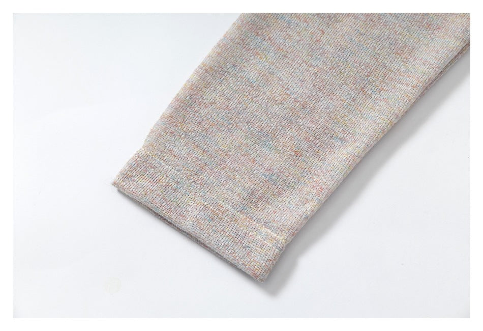 Close-up of a plain cuff or garment edge in pale multicolor heathered fabric.