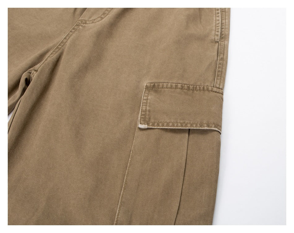 Close-up of tan pants showing a flap cargo pocket and visible stitching.