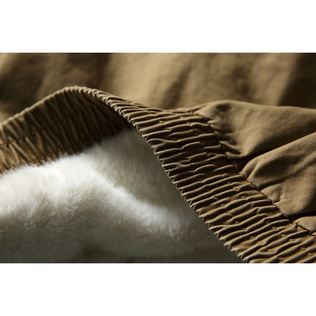 Close-up of the tan jacket's gathered edge and thick white plush lining.