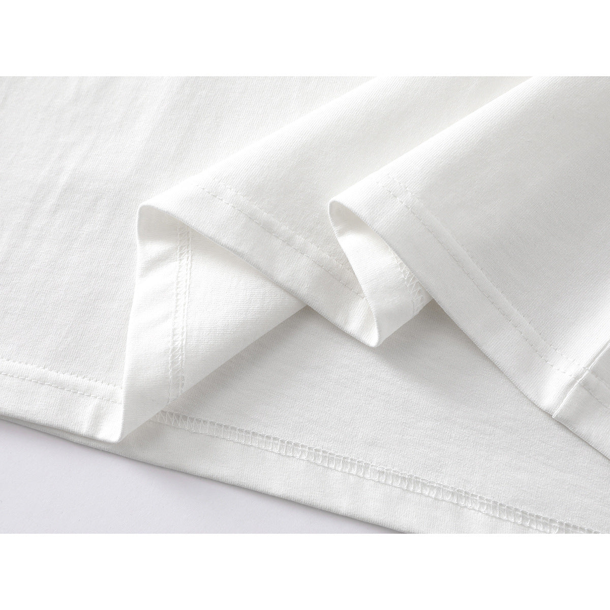 Close-up of the stitched hem and folded edge of a white T-shirt.