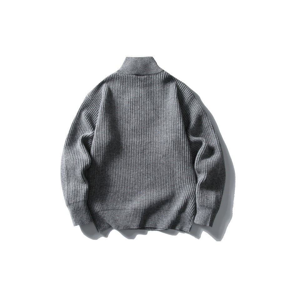 Back view of a gray rib-knit sweater with a high collar, long sleeves, and ribbed trim.