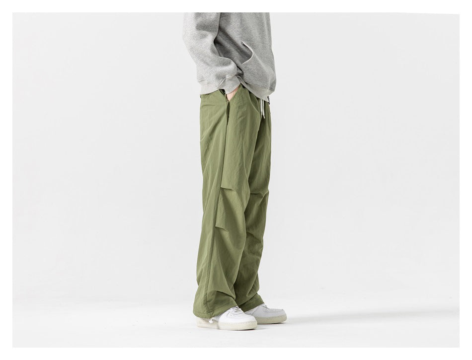 Side view of a model wearing loose olive-green pants with a large side pocket.