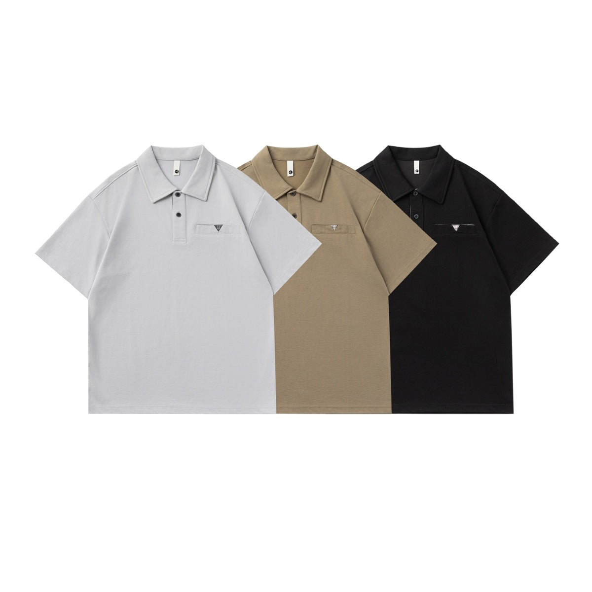 Three short-sleeve polo shirts shown from the front in light gray, taupe, and black, each with a chest pocket.