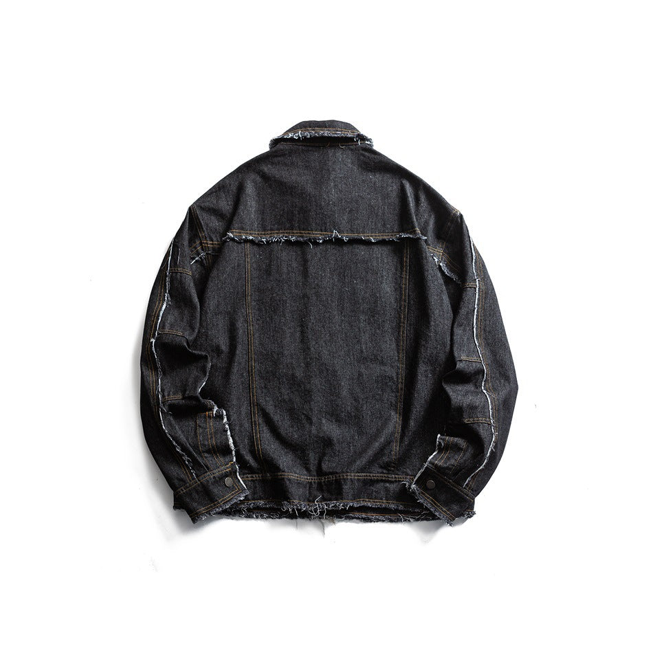 Back view of a charcoal-black denim jacket with a horizontal yoke seam and frayed edges.