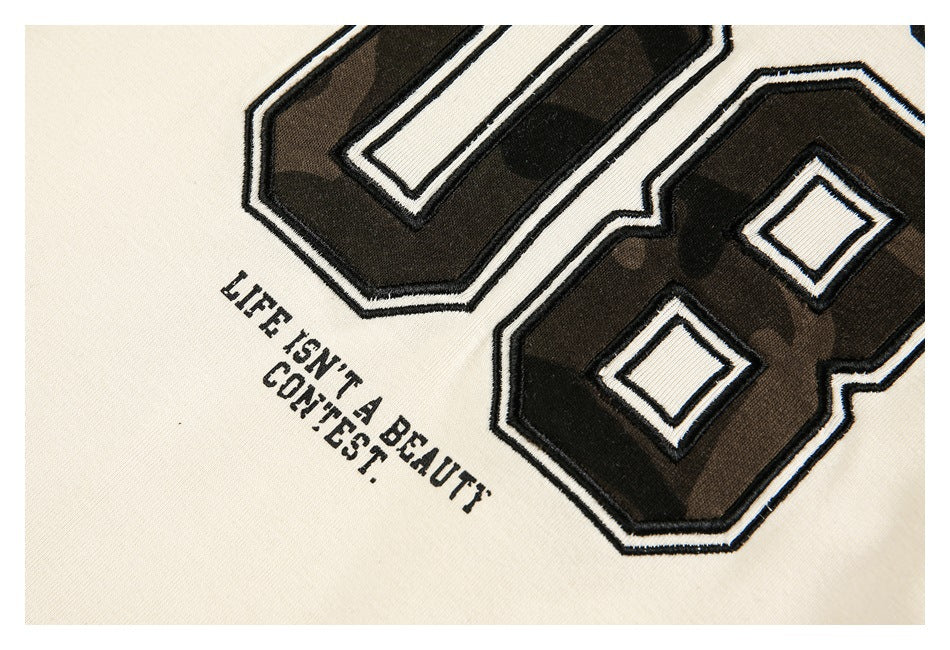 Close-up of the shirt's raised, outlined camouflage graphic and small English slogan.