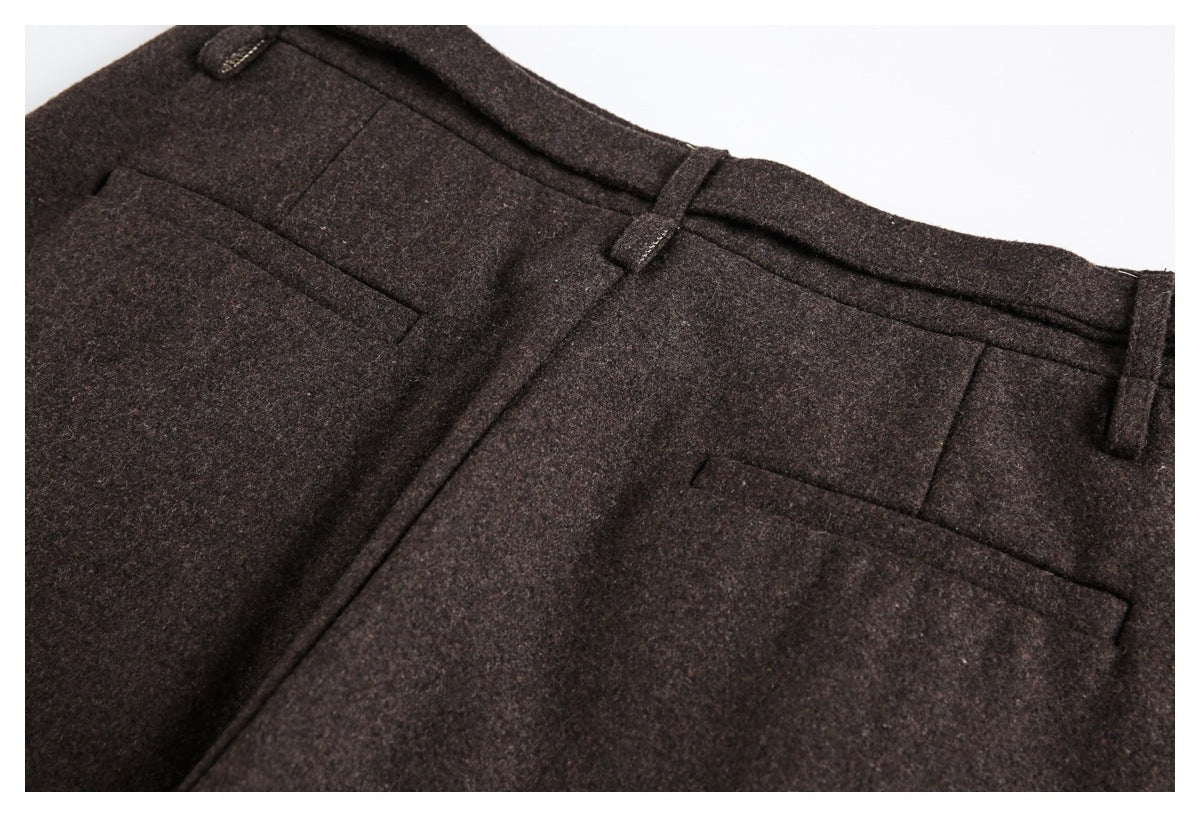Close-up of the back of dark brown trousers, showing belt loops and a welt pocket.