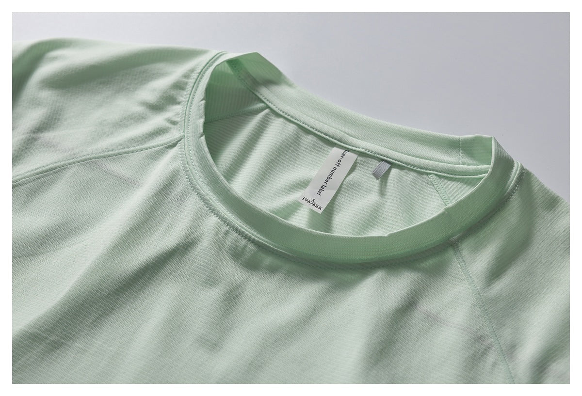 Close-up of the pale mint shirt's crew neckline, shoulder seams, and small sewn-in neck label.