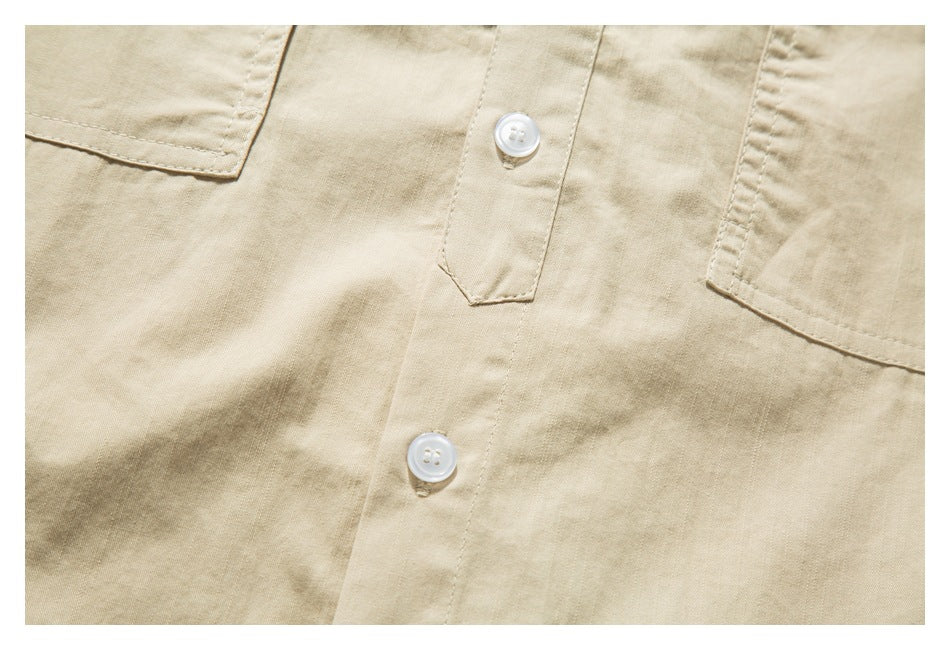 Close-up of the beige shirt's button placket and lower edges of two chest pockets.