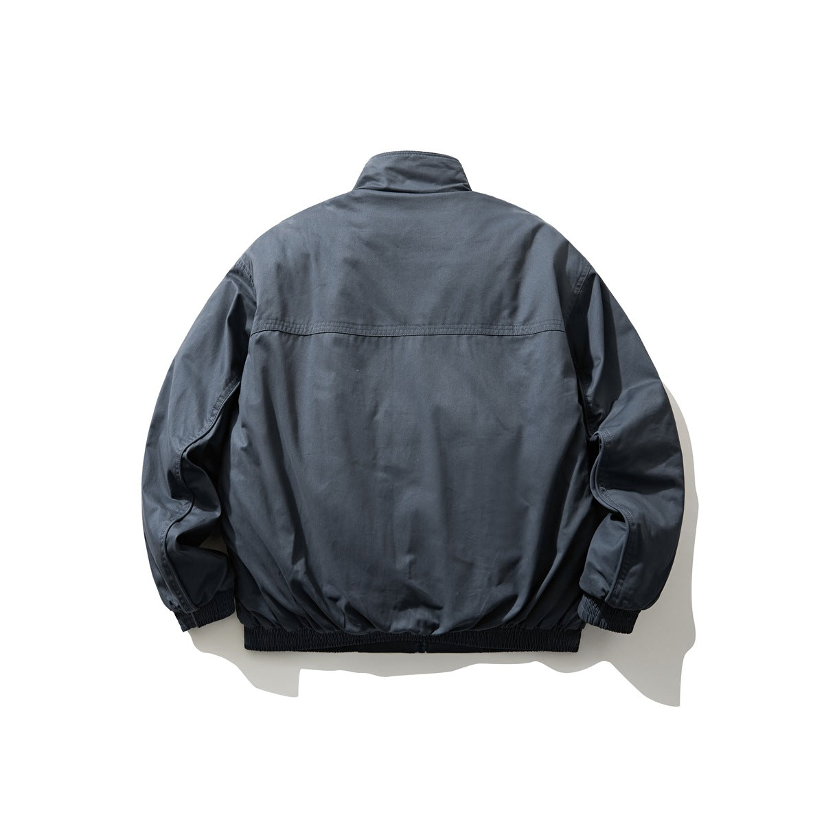 Back view of a charcoal blue stand-collar jacket with long sleeves and gathered cuffs and hem.