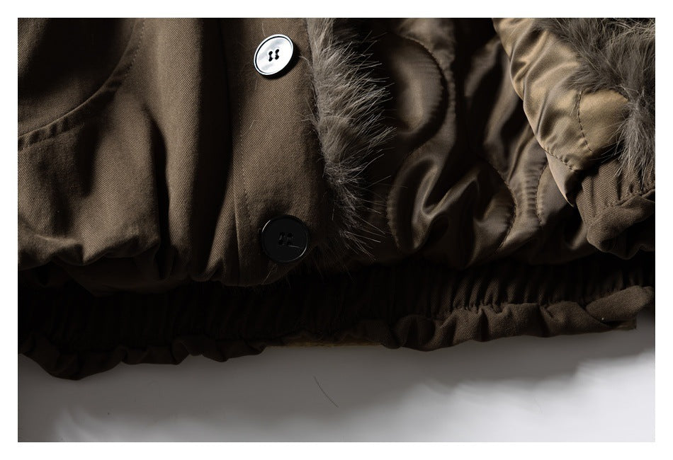 Close-up of a brown coat's buttoned edge, fur trim, shiny lining, and gathered hem.