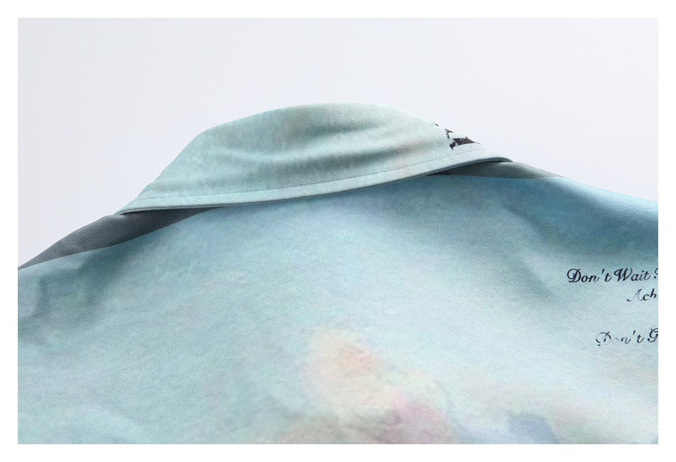 Close-up of the back collar and shoulder area of a pale aqua shirt with cloudy pastel print.