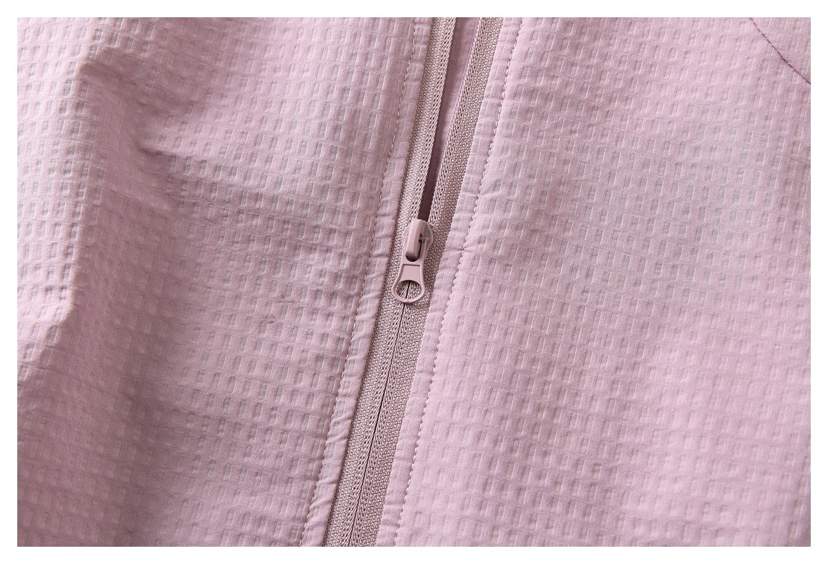 Close-up of the zipper and textured dusty pink fabric on a jacket.