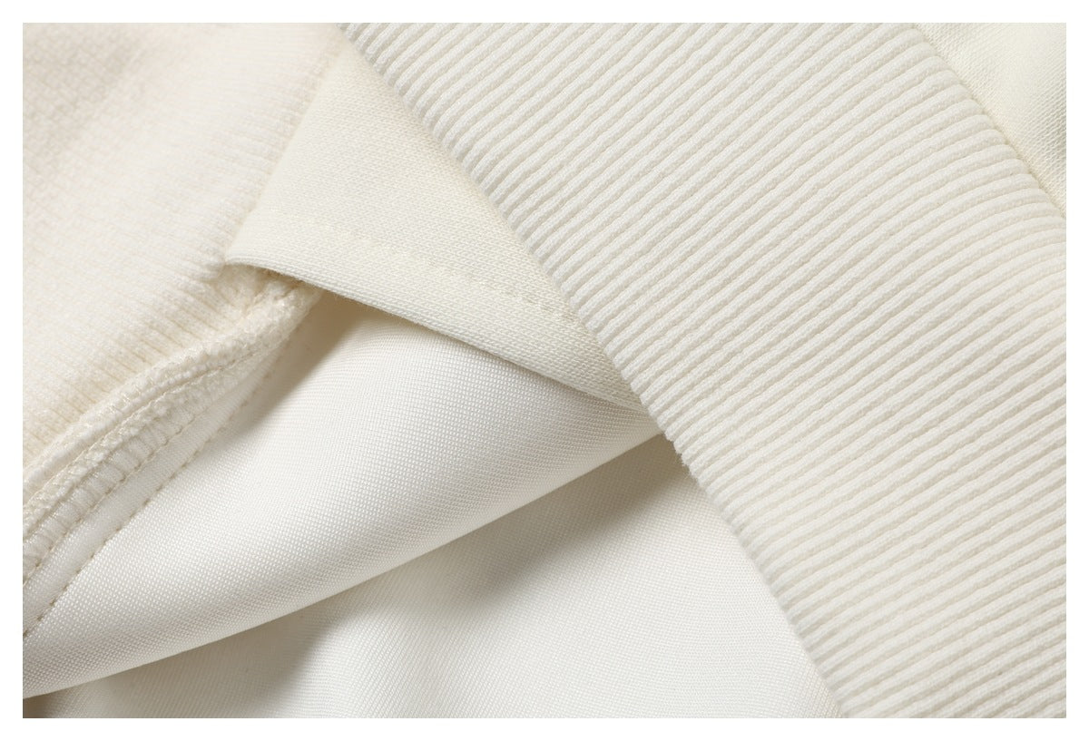 Close-up of ivory garment layers showing a ribbed edge and interior stitching.