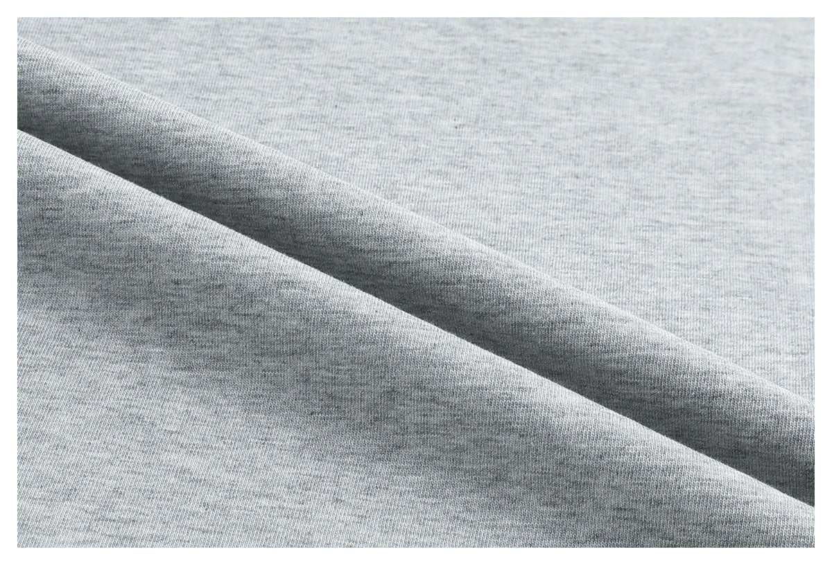Close-up of light gray knit fabric arranged in soft folds.