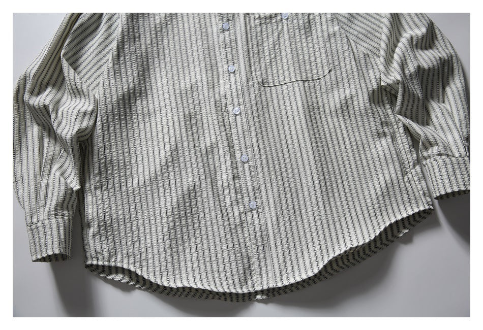 Flat-lay front of a cream long-sleeve button-up shirt with narrow black patterned stripes and a chest pocket.