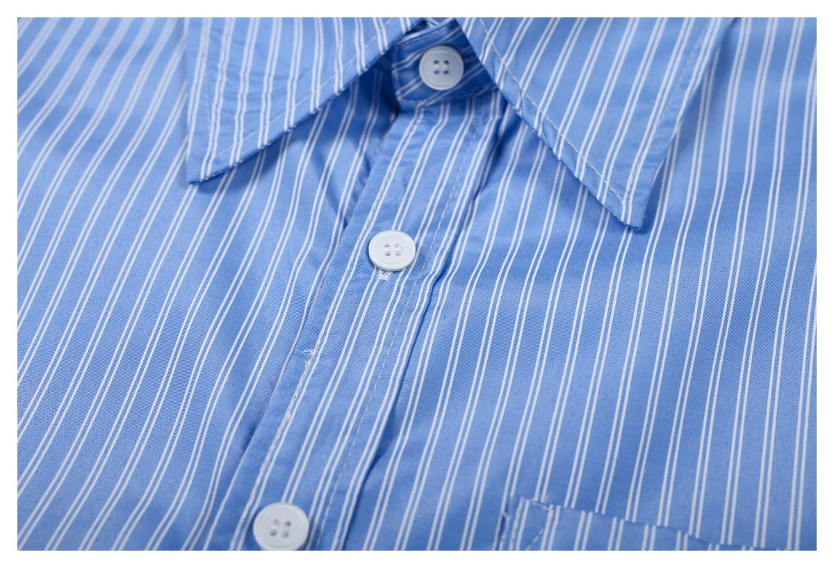Close-up of white buttons and the front placket on a blue-and-white striped shirt.