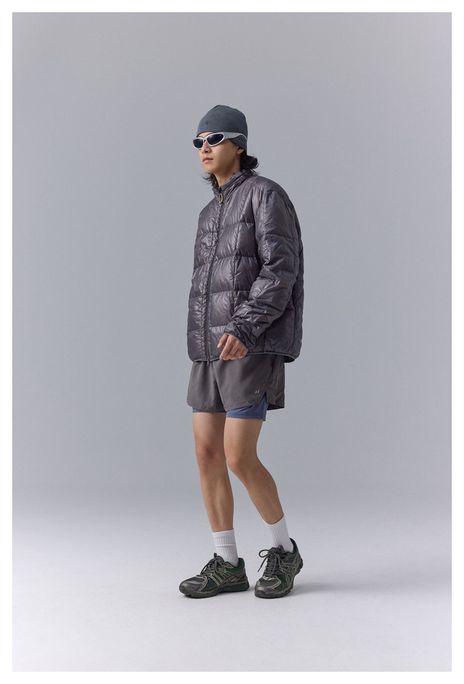 Model wearing a charcoal gray quilted zip jacket, shown at a three-quarter angle.