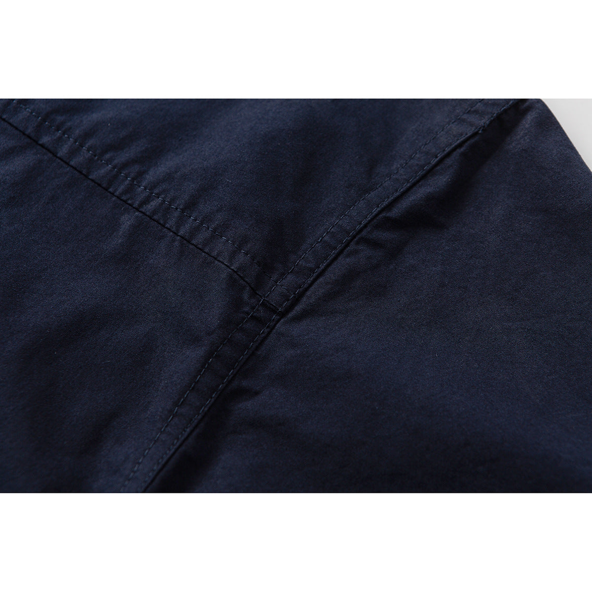 Close-up showing diagonal stitched seams on dark navy shirt fabric.