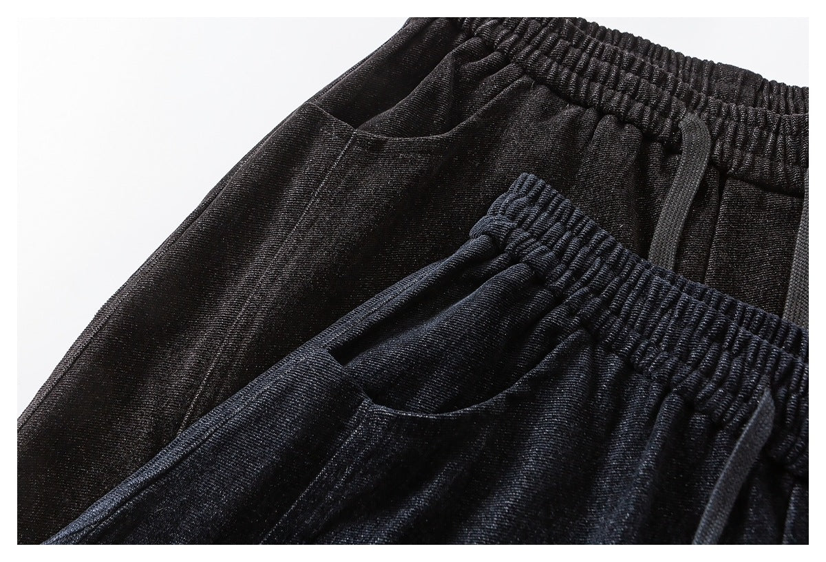 Close-up of the elastic waist and curved front pockets on dark navy and charcoal pants.