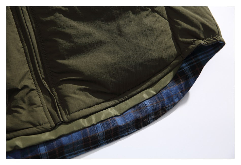 Close-up of the olive jacket's lower edge, revealing blue and brown plaid lining beneath the hem.