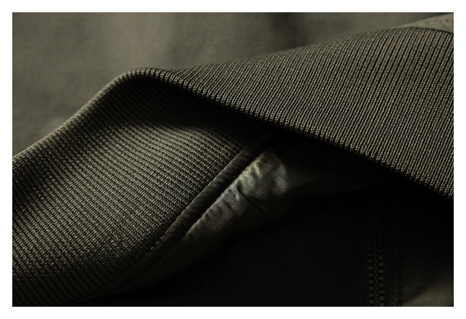 Close-up of dark ribbed fabric folded over a smooth inner panel, with a zipper visible near the edge.