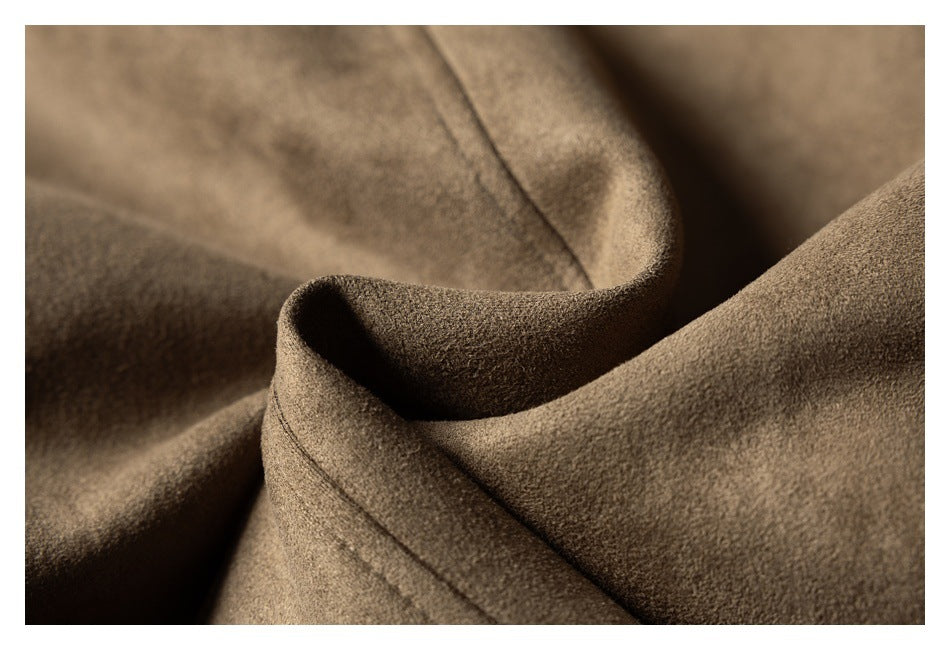 Close-up of the taupe-brown coat fabric folded to show its soft-looking surface and seam.