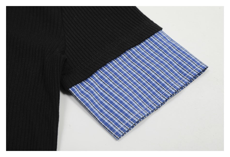 Close-up of a black ribbed sleeve ending in a blue plaid cuff.
