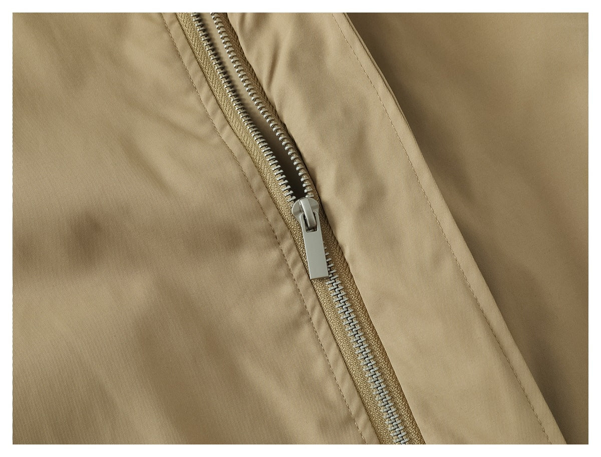 Close-up of a metal zipper and stitched seams on the tan jacket.