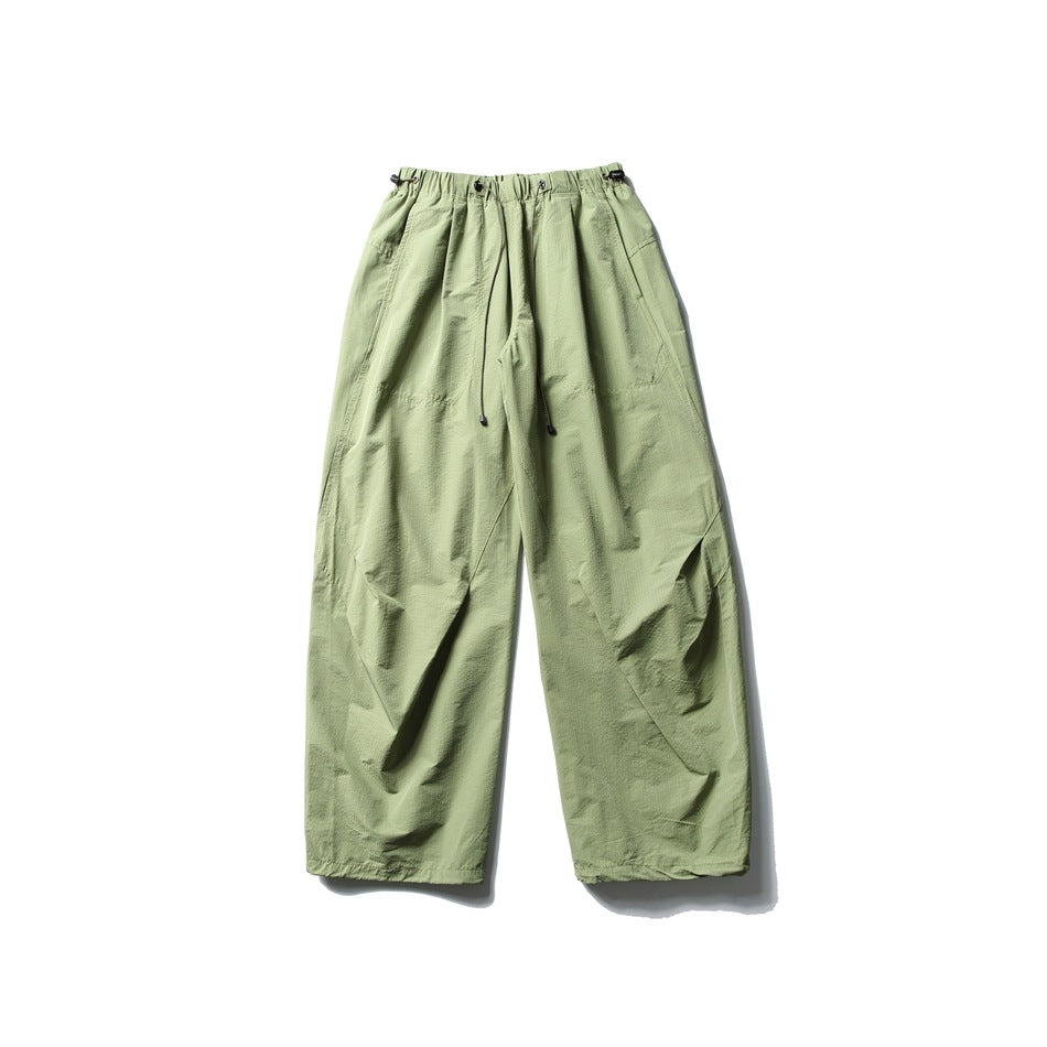 Green wide-leg parachute pants with drawcord elastic waistband, flat lay front view