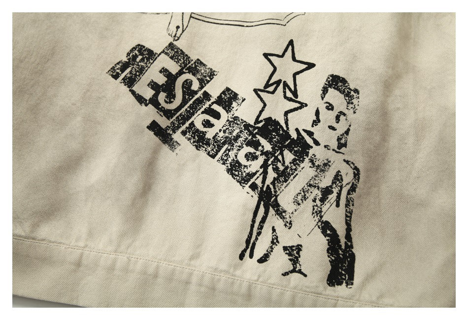 Close-up of a black printed graphic with stars and a figure on beige fabric.