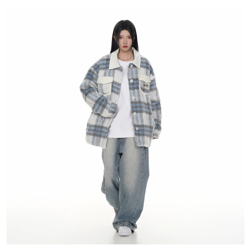 Model wearing an open gray, white and blue plaid jacket over a white top with loose blue jeans.