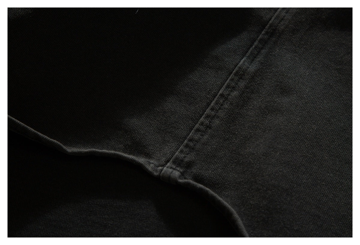 Close-up of a seam on dark charcoal-black garment fabric.