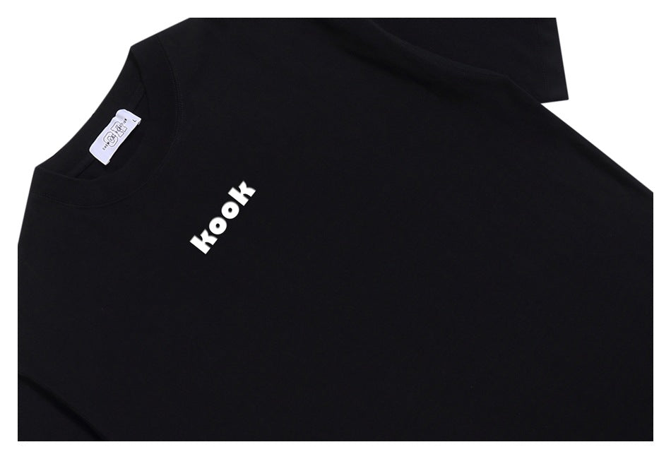 Black T-shirt laid flat, with a small white “kook” print on the chest and a visible neck label.