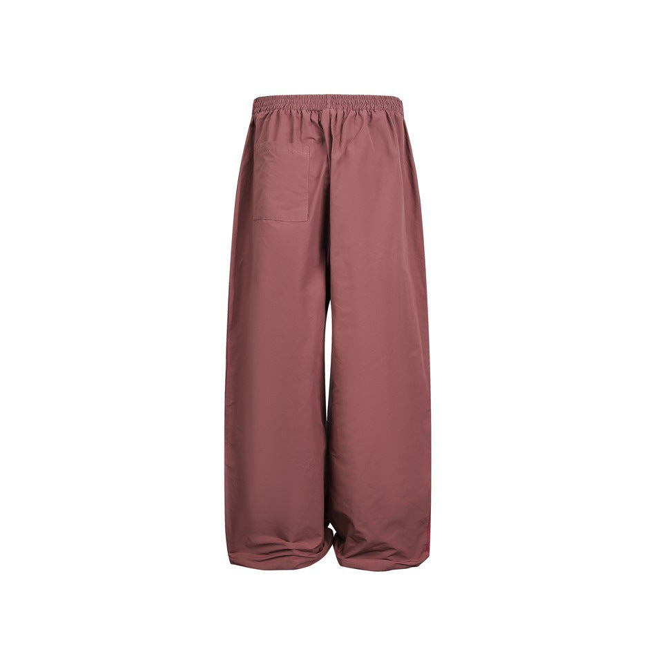 Back view of dusty rose wide-leg pants with an elastic waist and a rectangular patch pocket.
