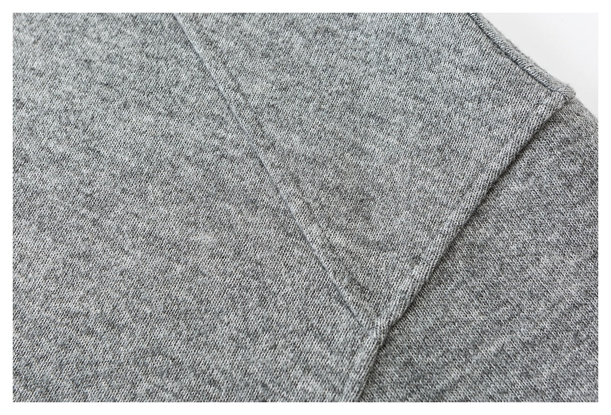 Close-up of heather gray knit fabric and a curved stitched seam.