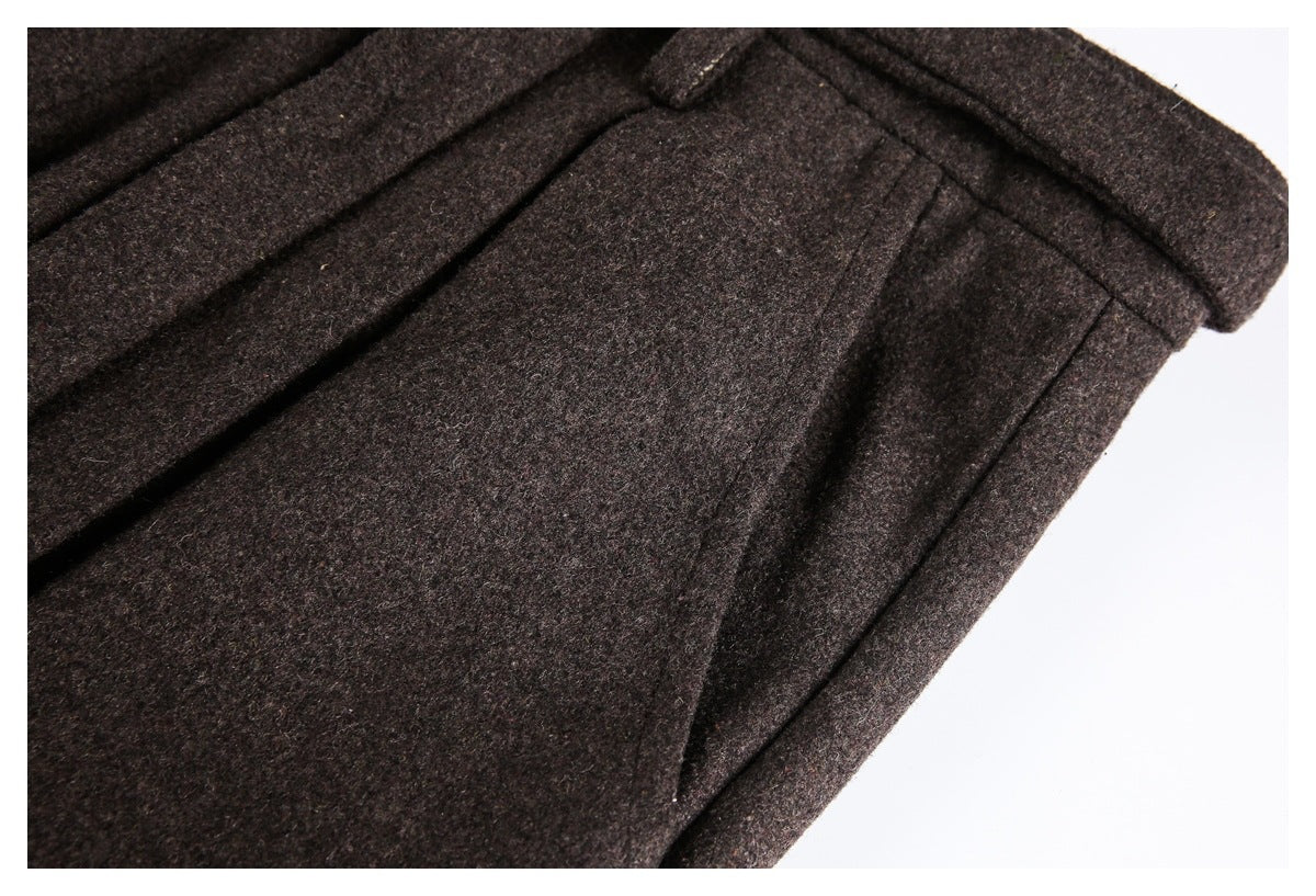 Close-up of dark brown trousers showing a seam and folded wool-like textured fabric.